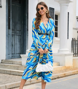 Detail of blue V-neck long sleeve dress with colorful wave patterns and a black belt