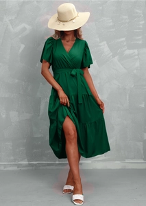 Detail view of the green V-neck dress featuring layered cake skirt and ruffled sleeves