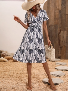 Close-up of V-neck summer dress with black leaf print and cinched waist for beach vacation