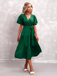 Detailed view of the dark green V-neck midi dress featuring tiered ruffle skirt layers