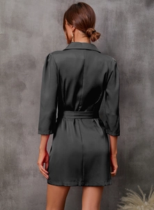 Detail view of the back of a black satin blazer dress with tie waist and 3/4 sleeves