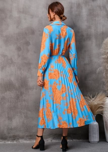 Détails d'une robe mi-longue bleu ciel à manches longues avec imprimé floral orange