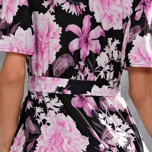Detail of the waist belt and floral print texture on the black summer V-neck dress