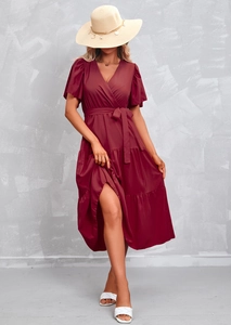 Detail view of burgundy wrap dress featuring a v-neckline and layered ruffle skirt