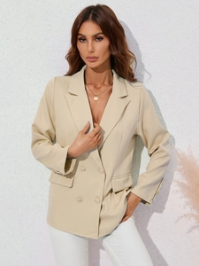 Détail d'un blazer beige à double boutonnage pour femme avec revers classiques et poches