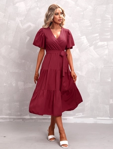 Detail of burgundy V-neck dress featuring ruffled sleeves and layered tiered skirt texture