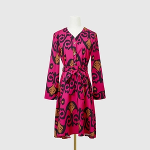 Close-up of elegant V-neckline and detailed damask print on long sleeve dress