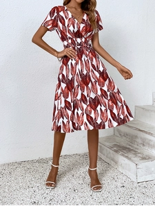 Detail of V-neck summer dress with tropical leaf print and smocked waist design