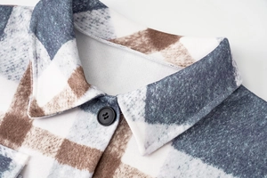 Close-up detail of lapel collar and black button on a long plaid wool coat