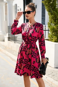 Detailed view of the vibrant magenta floral print and button-down design of the long dress