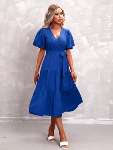 Detail of dark blue V-neck tiered dress with puff sleeves and waist tie belt