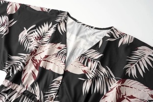 Close-up of V-neckline and tropical palm leaf print on lightweight black fabric