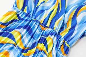 Detail of V-neck pleated dress with abstract blue and yellow wave print and elastic waist