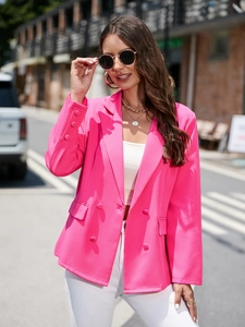 Détail d'un blazer croisé rose vif avec revers et boutons décoratifs aux poignets