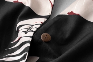 Detailed macro view of high-quality fabric texture and wooden button on a floral summer dress