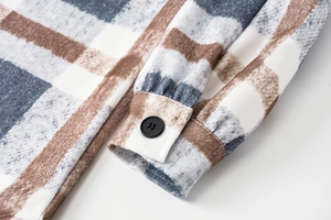 Detail of plaid wool coat cuff with blue and brown check pattern and black button