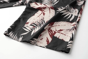 Close-up detail of tropical palm leaf print on lightweight black summer dress fabric