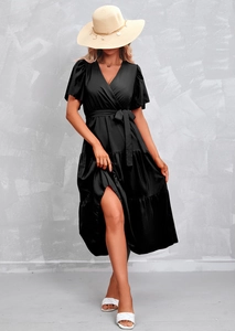 Detail of black V-neck wrap dress featuring tiered ruffle skirt and elegant waist tie