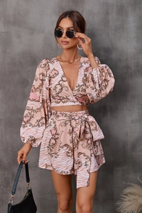 Detail of pink floral two-piece set featuring V-neck long sleeve top and tie-waist shorts