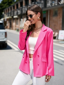 Détail du blazer croisé rose vif montrant les revers classiques et la texture du tissu