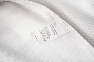 Detailed fabric care label showing 35% cotton and 65% polyester blend on winter coat