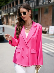 Détail d'un blazer croisé rose vif avec revers à encoche et poches à rabat