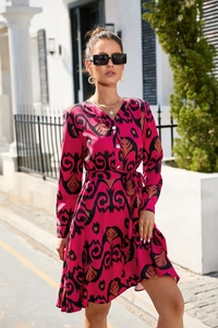 Detail of rose red chiffon dress with tribal print, V-neck, and white button closure
