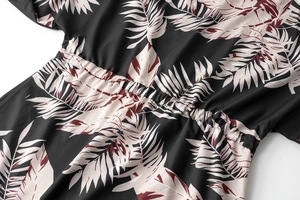 Detail of elasticized waist on a tropical leaf print dress with neat stitching