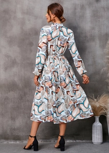 Détails de l'imprimé feuilles et de la taille ajustée sur la robe midi à manches longues