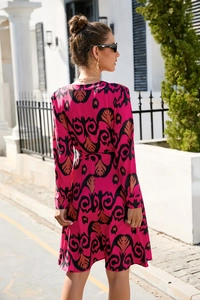 Detail of fuchsia long sleeve mini dress with vintage damask print and matching waist belt