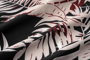 Detailed view of the tropical leaf print fabric in black, beige, and dark red tones