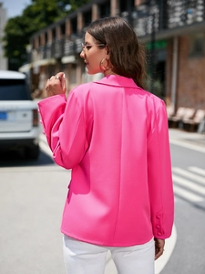 Détail de la manche d'un blazer rose vif avec quatre boutons décoratifs de couleur identique