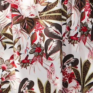 Gros plan sur l'imprimé floral tropical avec lys blancs et feuilles brun-rougeâtre