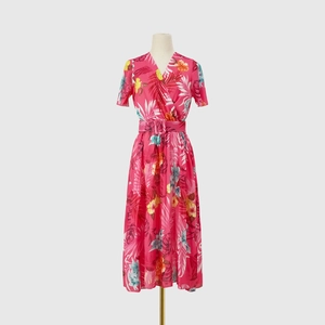 Close-up of pink tropical floral print fabric with pleated texture on a V-neck midi dress