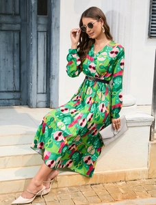 Detailed view of women's V-neck green floral pleated dress with long sleeves and black belt