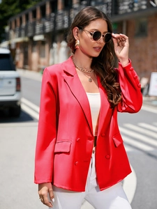 Détail d'un blazer rouge croisé avec revers à cran et boutons décoratifs aux poignets
