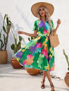 Detail of vibrant abstract print summer dress with pleated skirt and matching belt buckle