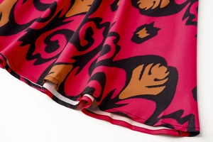 Detail of floral print hem on a long-sleeve dress with smooth chiffon texture and stitching