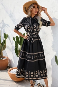 Detailed pattern of a vintage black dress featuring beige tulip and crescent motifs