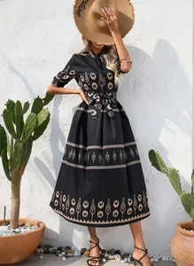 Detail of floral print on a black midi dress with a collared neck and matching waist belt