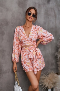 Detail of floral two-piece set with long-sleeve V-neck crop top and belted high-waisted shorts