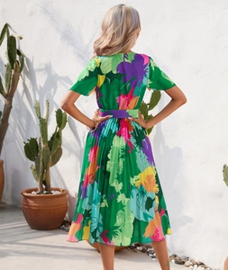 Detail of vibrant green floral pleated midi dress with back V-neck and printed waist tie