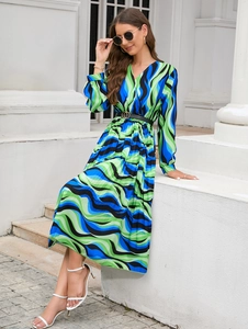 Detail of V-neck long sleeve dress with abstract wave print and pleated skirt finish