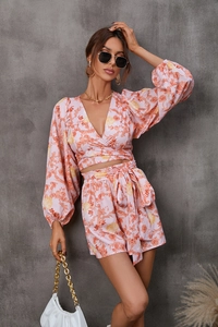 Detail of pink floral two-piece set featuring a deep V-neck top and belted high-waist shorts