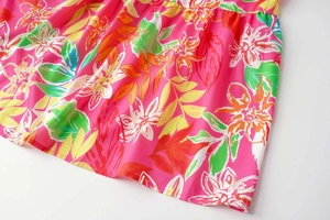 Detail of pink tropical floral print on a summer dress hem with precise stitching
