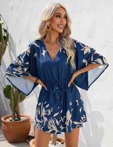 Detailed view of dark blue chiffon dress with white tropical leaf print and V-neckline