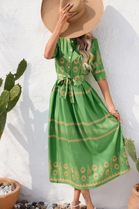 Detail of bohemian green maxi dress featuring vintage yellow geometric prints and tied waist
