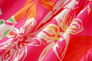 Detailed macro shot of tropical leaf pattern on breathable floral print summer dress fabric