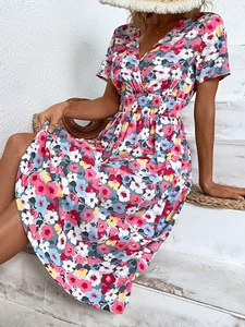 Detail of V-neck summer floral midi dress with elastic smocked waist and vibrant petal print