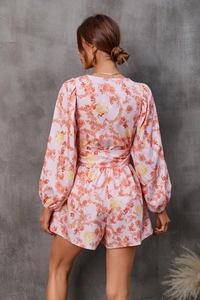 Detailed back view of pink floral long sleeve romper with V-neck and waist tie design
